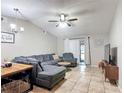 Comfortable living room featuring a large sectional sofa, ceiling fan, and sliding glass doors at 1803 Foxhall Cir # 1803, Kissimmee, FL 34741