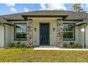 Inviting entryway featuring stone column accents, a dark front door, and beautifully landscaped greenery at 19073 Sabal St, Orlando, FL 32833