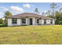 Attractive single-story house featuring lush green lawn and a neutral stucco facade, stone accents, and dark-framed windows at 19073 Sabal St, Orlando, FL 32833