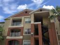 Well-maintained condo exterior with balconies, stairs, and lush landscaping, under a partly cloudy sky at 1950 Summer Club Dr # 202, Oviedo, FL 32765