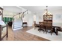 An open-concept home featuring a wood dining table near a curved staircase at 2607 Stanmore Ct, Orlando, FL 32817