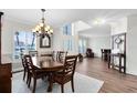 Formal dining area with hardwood floors, a large window and a traditional chandelier at 2607 Stanmore Ct, Orlando, FL 32817