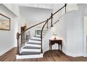 Bright foyer with a curved staircase featuring dark wood treads and white risers and banister at 2607 Stanmore Ct, Orlando, FL 32817