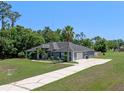 Wide angle view of the home with a spacious driveway, and lush landscaping at 2633 Pickett Downs Dr, Chuluota, FL 32766