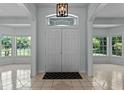 Bright foyer featuring tiled floors, columns, and decorative lighting at 2633 Pickett Downs Dr, Chuluota, FL 32766