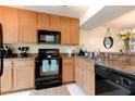Functional kitchen featuring wooden cabinetry and essential appliances for cooking convenience at 2818 Plaza Terrace Dr # 2818, Orlando, FL 32803