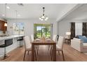 Elegant dining area adjacent to the kitchen, featuring a contemporary chandelier and outdoor views at 2940 Nottel Dr, St Cloud, FL 34772