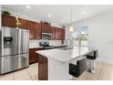 Modern kitchen with stainless steel appliances, a quartz countertop island, and stylish dark wood cabinetry at 2940 Nottel Dr, St Cloud, FL 34772