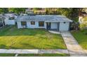 Eye-level view of a single-story home with a green lawn and tidy landscaping at 3927 Citadel Dr, Orlando, FL 32839