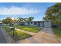 Landscaped front yard view of this cozy home, complete with a well-kept lawn and paved driveway at 3927 Citadel Dr, Orlando, FL 32839