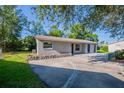 Single-story home with a concrete driveway, side yard, and stone accent walls at 4226 Kelly Miller Ct, Orlando, FL 32811