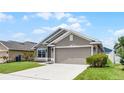 Well-maintained home with a two-car garage, lush green lawn, and beautiful landscaping at 503 Meadow Pointe Dr, Haines City, FL 33844