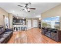 Open-concept living area with hardwood floors, a ceiling fan, and a view into the modern kitchen at 5515 Windsong Oak Dr, Leesburg, FL 34748
