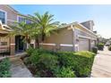 Landscaped front yard of home, featuring tropical plants and a two-car garage at 585 Cruz Bay Cir, Winter Springs, FL 32708