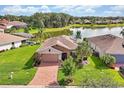 Beautiful home overlooking a scenic lake, surrounded by lush greenery and a brick paved driveway at 634 Via Corso Ct, Kissimmee, FL 34759