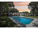 Backyard features a sparkling pool, surrounded by a well-maintained lawn and lush greenery, ideal for relaxation at 641 Peachwood Dr, Altamonte Springs, FL 32714