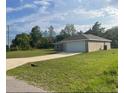 A single-story home featuring a two-car garage, driveway, and well-maintained lawn at 74 Malauka Pass, Ocklawaha, FL 32179