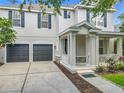 Two-story home featuring a welcoming front porch, dark shutters, two-car garage, and a well-maintained front yard at 9942 Sweetleaf St, Orlando, FL 32827