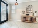Light-filled foyer featuring tile flooring, a decorative mirror, and a glass-paneled front door at 9942 Sweetleaf St, Orlando, FL 32827