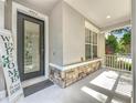 Covered front porch of home featuring stacked stone accents, a welcome sign, and decorative glass door at 9942 Sweetleaf St, Orlando, FL 32827