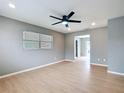 Bright living room featuring light wood floors, neutral walls, and contemporary ceiling fan at 116 7Th St, Winter Haven, FL 33880
