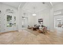 Bright living room with high ceilings, herringbone floors, modern furnishings, and abundant natural light at 1266 Saint Albans Loop, Lake Mary, FL 32746
