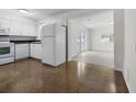 Bright kitchen featuring white cabinets, appliances, and seamless access to the adjacent living area at 1340 Continental Dr, Daytona Beach, FL 32117