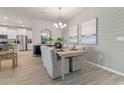 Bright dining room featuring modern decor, wood style flooring, and a stylish light fixture at 2080 Ashwood Bluff Dr, Ocoee, FL 34761