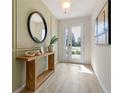 Inviting entryway with a wood table, mirror, decor and natural light at 2080 Ashwood Bluff Dr, Ocoee, FL 34761