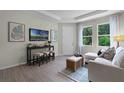 Bright living room features wood-look tile floors, large windows, and contemporary furnishings at 2117 Greenwood Oak Dr, Ocoee, FL 34761