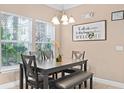 Cozy dining area with a chandelier and a decorative sign and lots of natural light from the window at 2952 Lucayan Harbour Cir # 105, Kissimmee, FL 34746