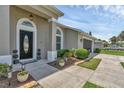 A welcoming property showcasing a landscaped walkway, well-kept lawn, and a view of the garage and driveway at 445 Oakland Park Blvd, Port Orange, FL 32127