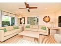 Well-lit living room with hardwood floors, neutral sofas and a large window creating a welcoming atmosphere at 507 N Peninsula Ave, New Smyrna Beach, FL 32169