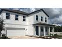 Stunning two-story home with a two-car garage, classic white siding, and covered porch at 710 Junonia Blvd, New Smyrna Beach, FL 32168