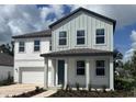 Charming two-story home with light gray and white siding, well-manicured landscaping, and covered front porch at 710 Junonia Blvd, New Smyrna Beach, FL 32168