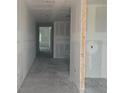 Unfinished hallway showcasing the potential for customization, with smooth concrete floors and ready-to-paint walls at 710 Junonia Blvd, New Smyrna Beach, FL 32168