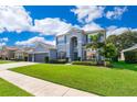 Charming two-story home featuring a manicured lawn and lush landscaping, showcasing curb appeal at 7263 Winding Lake Cir, Oviedo, FL 32765