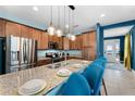 Modern kitchen with granite countertops, stainless steel appliances, and stylish pendant lighting at 7521 Marker Ave, Kissimmee, FL 34747