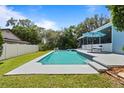 A backyard featuring a pristine pool with a spacious patio, and a manicured lawn at 8554 Amber Oak Dr, Orlando, FL 32817