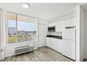 Bright kitchen featuring white cabinets, gray countertops, and updated appliances with a window view at 935 S Atlantic Ave # 302, Daytona Beach, FL 32118