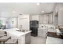 Modern kitchen with granite countertops, stainless steel appliances, and a breakfast bar at 103 Orchid Ct, Poinciana, FL 34759