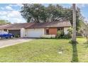 Single-story home with an attached garage, driveway, lawn, and front entry area with greenery at 109 Long Leaf Pine Cir, Sanford, FL 32773