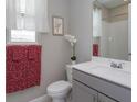 Well-lit bathroom with a modern vanity, framed art, and stylish floral accents and complementary towels at 1132 Sugarwood St, Davenport, FL 33837