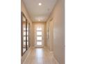 Inviting hallway with neutral tones, tiled flooring, recessed lighting and decorative mirrors on the wall at 1132 Sugarwood St, Davenport, FL 33837