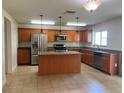 Spacious kitchen features stainless steel appliances, wood cabinets and granite countertops at 1325 Bella Coola Dr, Orlando, FL 32828