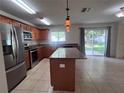 Bright kitchen with stainless appliances, center island, granite counters and tile floors at 1325 Bella Coola Dr, Orlando, FL 32828