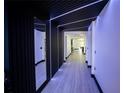 Modern hallway featuring unique architectural lighting and contrasting dark paneled walls at 13851 Rushing Creek Run, Orlando, FL 32824
