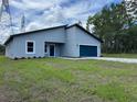 Charming single-story home with a blue garage door and a well-manicured front lawn at 16494 Sw 54Th Court Rd, Ocala, FL 34473