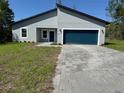 Charming single-story home with a blue garage door and a well-manicured front lawn at 16494 Sw 54Th Court Rd, Ocala, FL 34473
