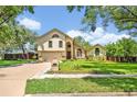 Charming two-story home with a well-maintained lawn and mature trees at 1905 Old Club Pt, Maitland, FL 32751